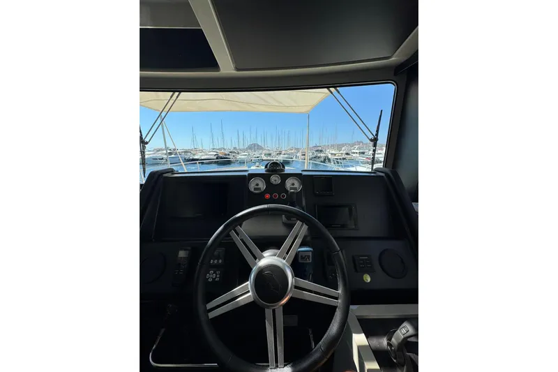  Yacht Photos Pics 2022 Cranchi T55 Trawler helm with marina view through windshield.