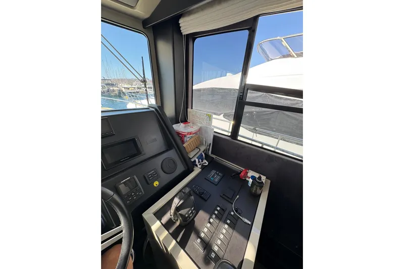 Yacht Photos Pics 2022 Cranchi T55 Trawler helm with navigation controls and marina view.