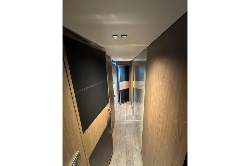  Yacht Photos Pics Interior hallway of 2022 Cranchi T55 Trawler, featuring sleek wood paneling and modern design.