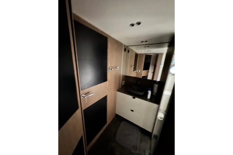  Yacht Photos Pics Modern bathroom interior of 2022 Cranchi T55 Trawler yacht with sleek wood and black finishes.
