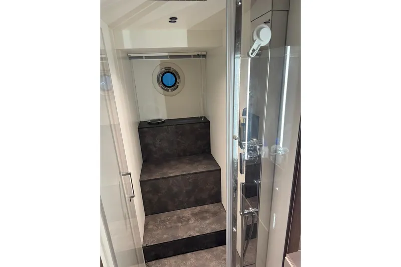  Yacht Photos Pics Interior stairs of 2022 Cranchi T55 Trawler with porthole window.