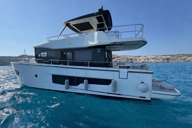  Yacht Photos Pics 2022 Cranchi T55 Trawler yacht on clear blue water, side view.