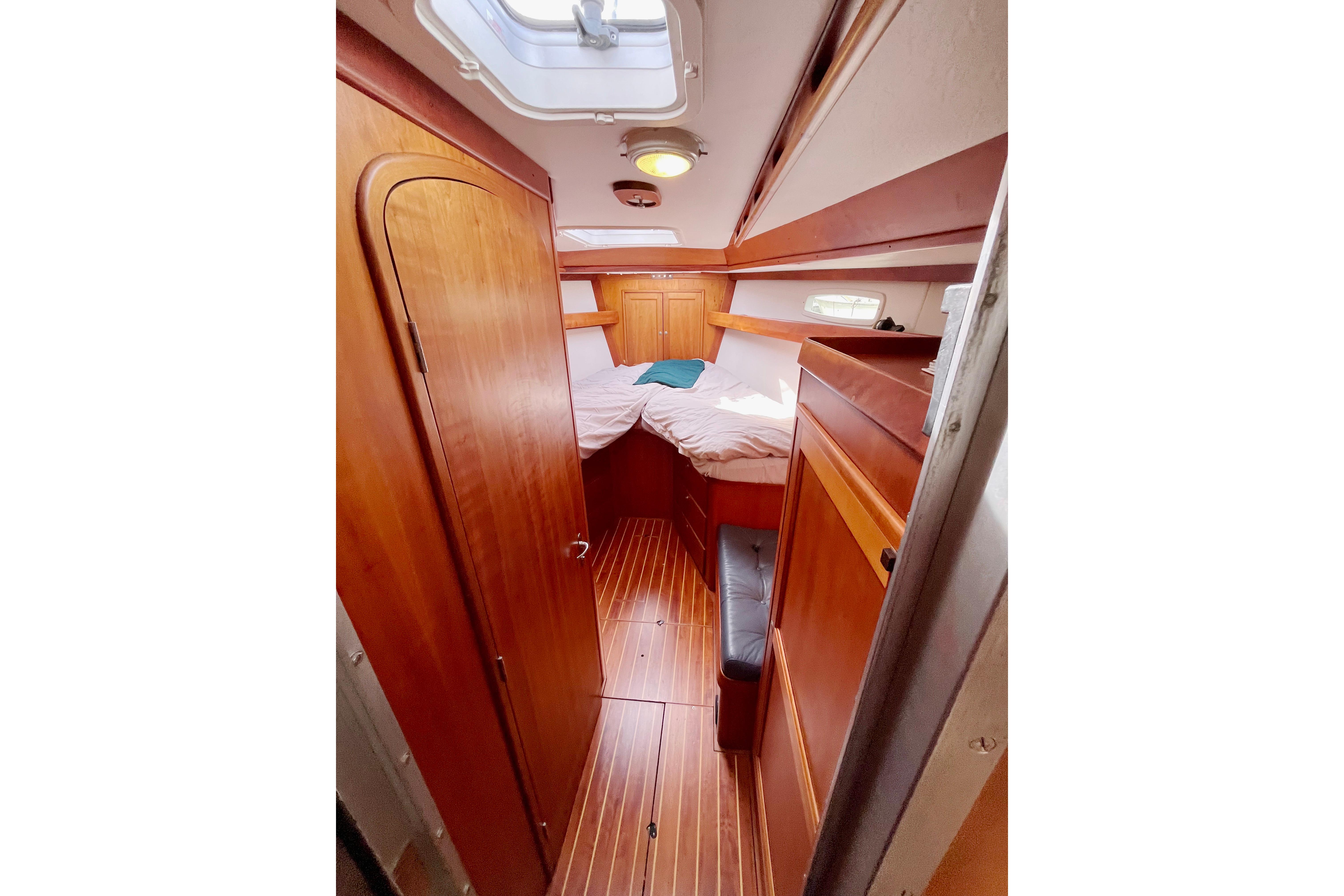 Cozy cabin interior of 1995 Able Apogee 50 sailboat with wooden furnishings.