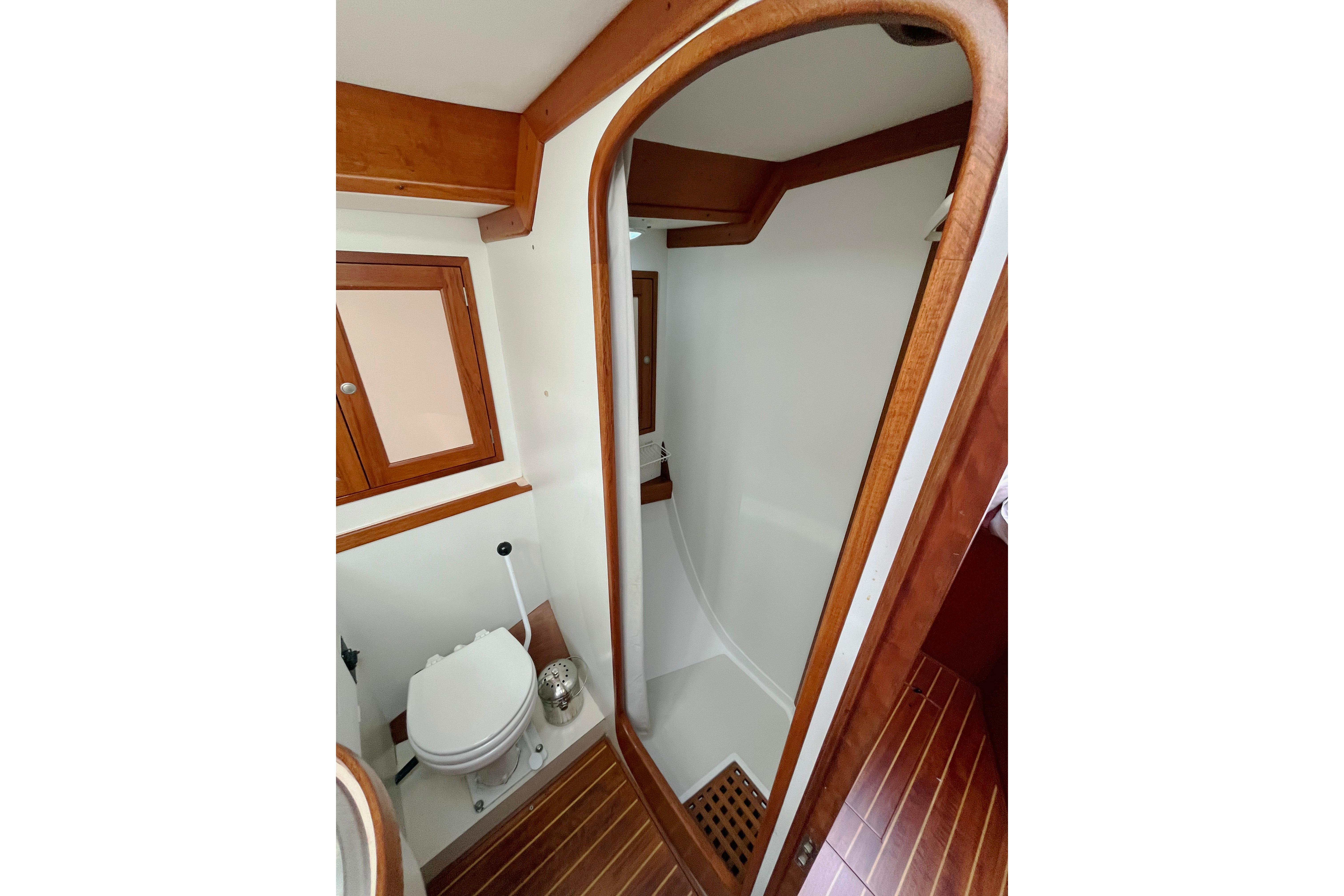 Bathroom interior of 1995 Able Apogee 50 yacht with wooden accents and shower.