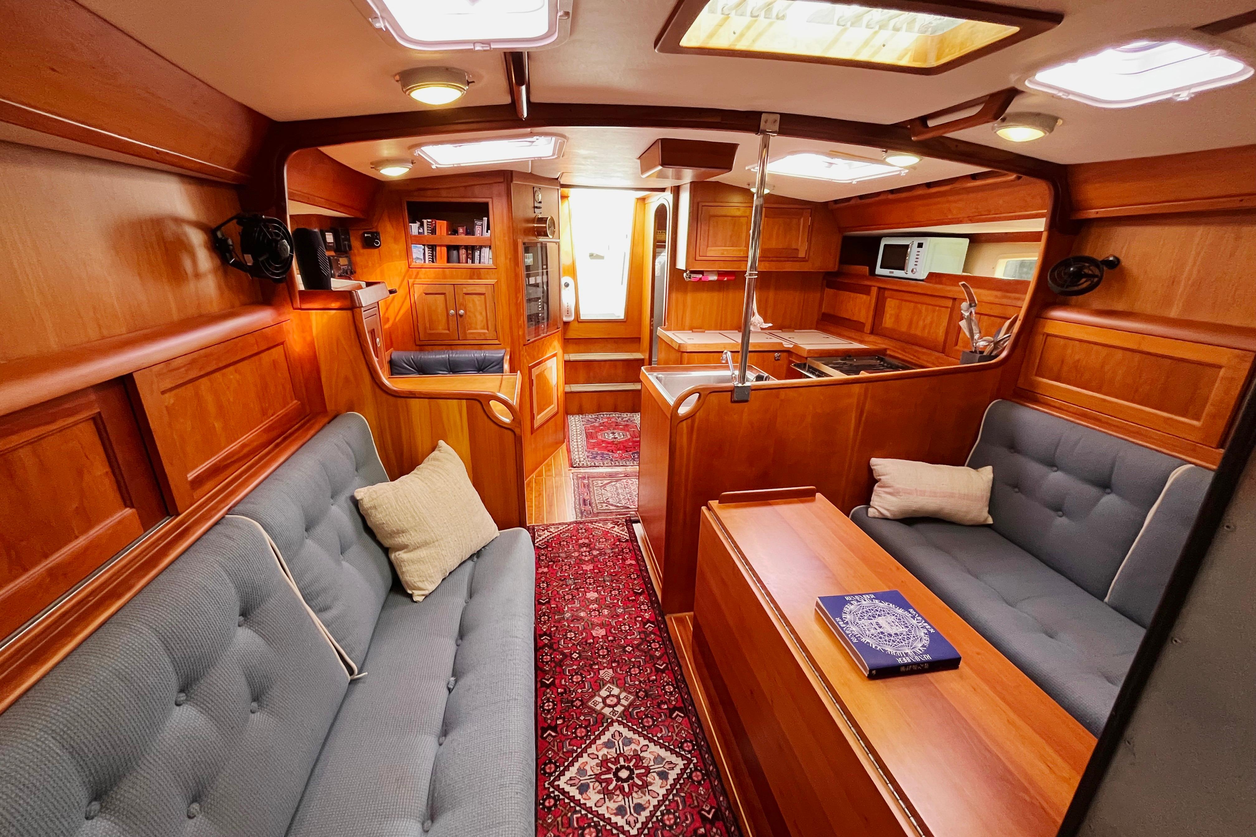 Luxurious interior of 1995 Able Apogee 50 yacht with wood paneling and plush seating.
