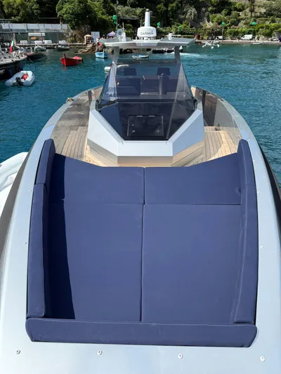  Yacht Photos Pics 2019 Wally Tender 48 yacht with blue sunbed, docked in a scenic harbor.