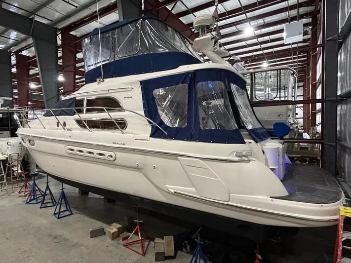  Yacht Photos Pics 2000 Sealine F44 yacht in storage, featuring blue canopy and sleek design.