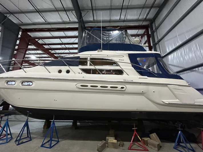 Yacht Photos Pics 2000 Sealine F44 yacht in storage, elevated on stands in a metal warehouse.