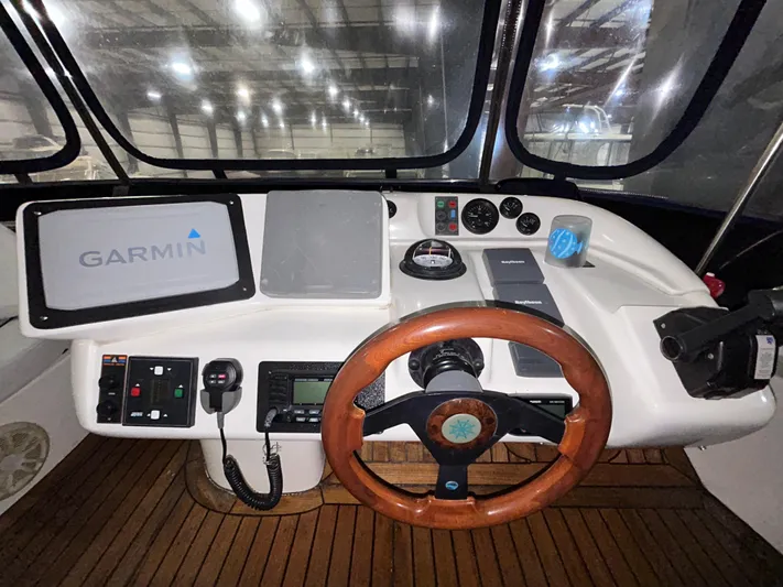  Yacht Photos Pics Sealine F44 2000 yacht helm with Garmin navigation, wooden steering wheel, and control panel.