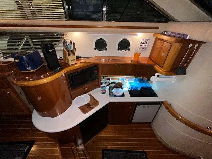  Yacht Photos Pics Interior of a 2000 Sealine F44 yacht kitchen with wooden cabinetry and modern appliances.