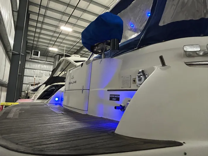  Yacht Photos Pics Sealine F44 yacht from 2000 in a storage facility with blue accent lighting.