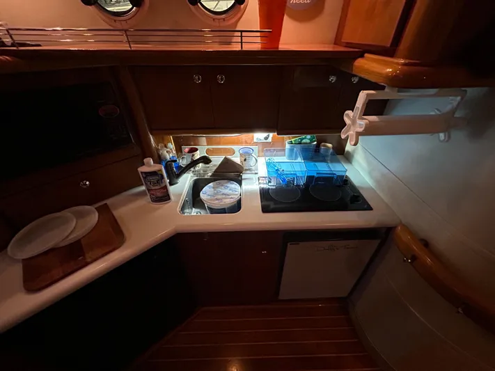  Yacht Photos Pics Sealine F44 2000 yacht kitchen with sink, stove, and wooden cabinetry.