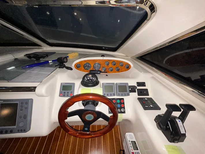  Yacht Photos Pics Cockpit of a 2000 Sealine F44 yacht with wooden steering wheel and navigation instruments.