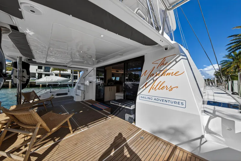  Yacht Photos Pics Luxurious 2019 Leopard 58 yacht deck with seating, "The Maritime Millers" branding, and waterfront view.