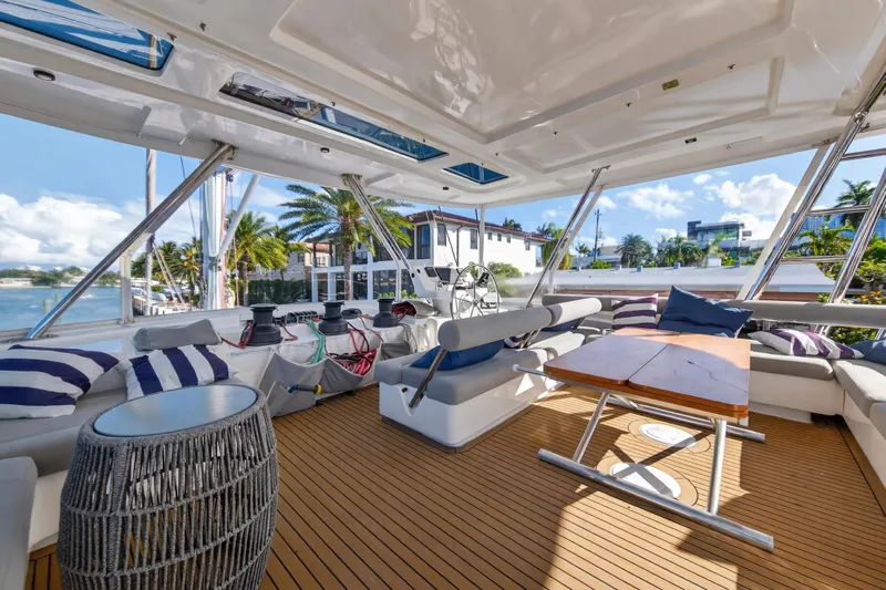  Yacht Photos Pics Luxurious 2019 Leopard 58 yacht interior with spacious seating, wooden deck, and scenic waterfront view.