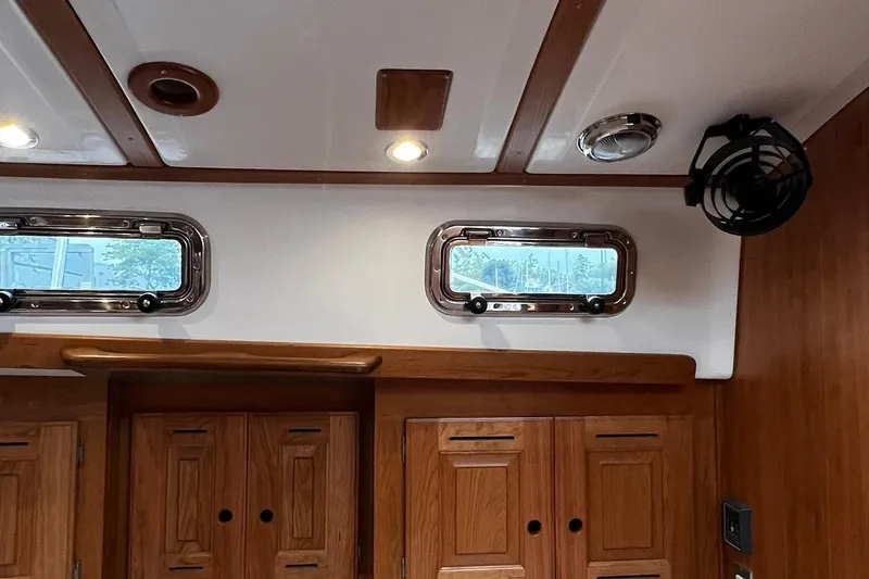395 Yacht Photos Pics Interior of 2025 Tartan 395 yacht with wooden cabinets and porthole windows.