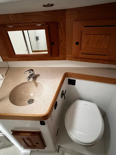 395 Yacht Photos Pics Compact bathroom in 2025 Tartan 395 yacht with sink, toilet, and wooden cabinetry.