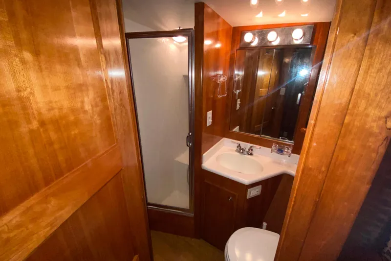It's About Time Yacht Photos Pics Compact bathroom in a 2001 Californian 39 yacht, featuring wood paneling and modern fixtures.