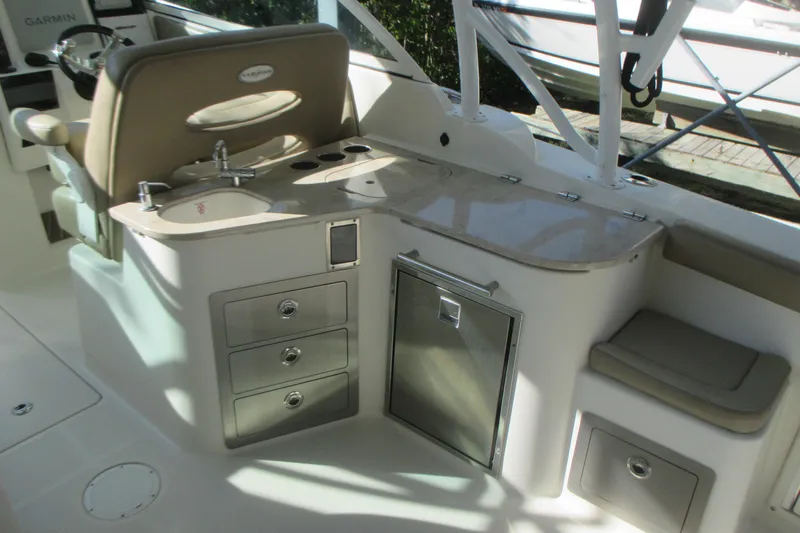 Yacht Photos Pics 2019 Sailfish 325 DC boat interior with sink, storage drawers, and seating area.