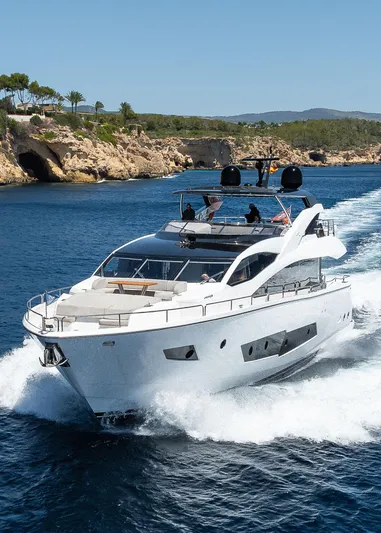 Seawater Yacht Photos Pics 2019 Sunseeker 86 Yacht cruising on blue ocean near rocky coastline.