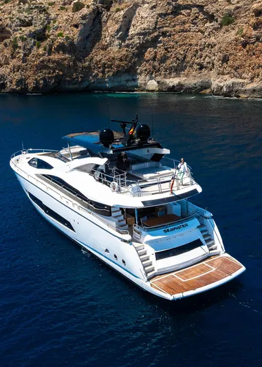 Seawater Yacht Photos Pics Luxurious 2019 Sunseeker 86 Yacht cruising in clear blue waters near rocky coastline.