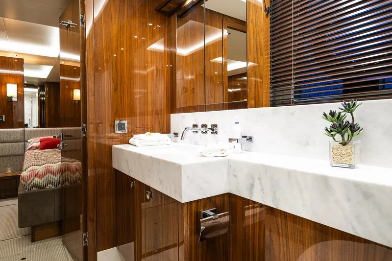 Seawater Yacht Photos Pics Luxurious bathroom interior of 2019 Sunseeker 86 Yacht with marble sink and wooden accents.