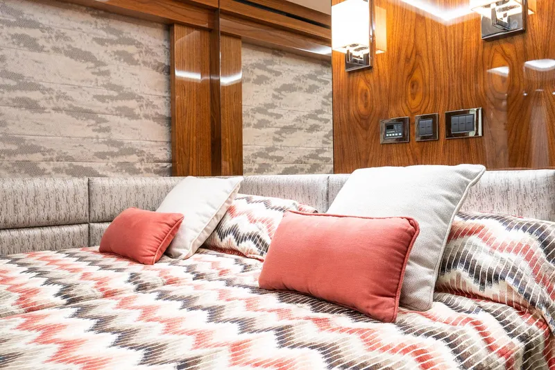 Seawater Yacht Photos Pics Luxurious bedroom interior of 2019 Sunseeker 86 Yacht with patterned bedding and wood accents.