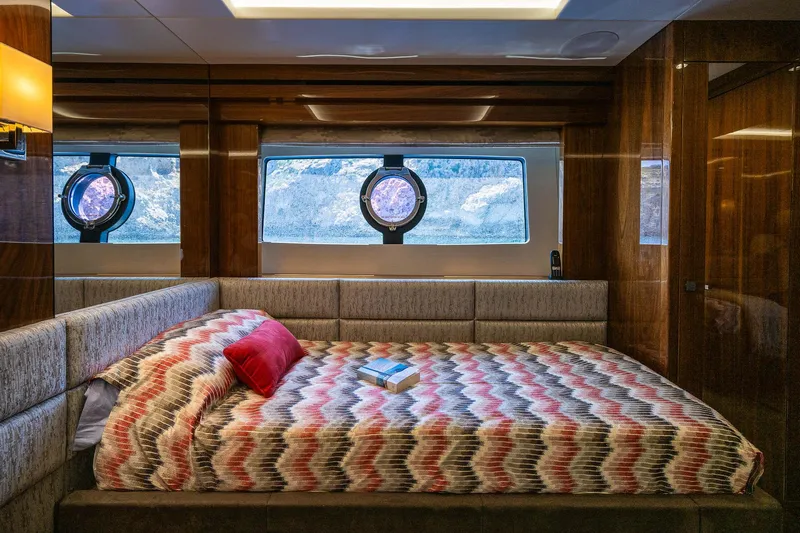 Seawater Yacht Photos Pics Luxurious bedroom interior of 2019 Sunseeker 86 Yacht with patterned bedding and scenic window view.