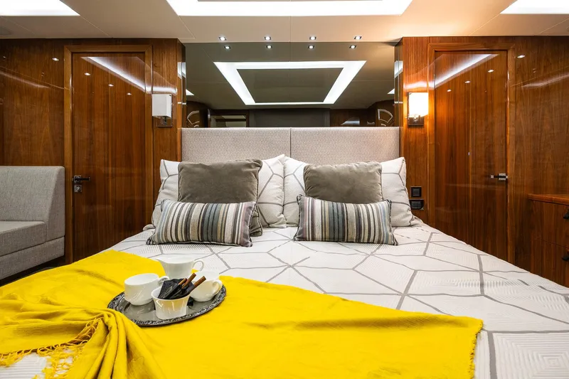 Seawater Yacht Photos Pics Luxurious bedroom interior of 2019 Sunseeker 86 Yacht with elegant bedding and wooden accents.