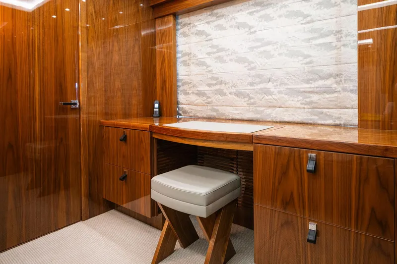 Seawater Yacht Photos Pics Luxurious wooden interior of 2019 Sunseeker 86 Yacht with elegant desk and cushioned stool.