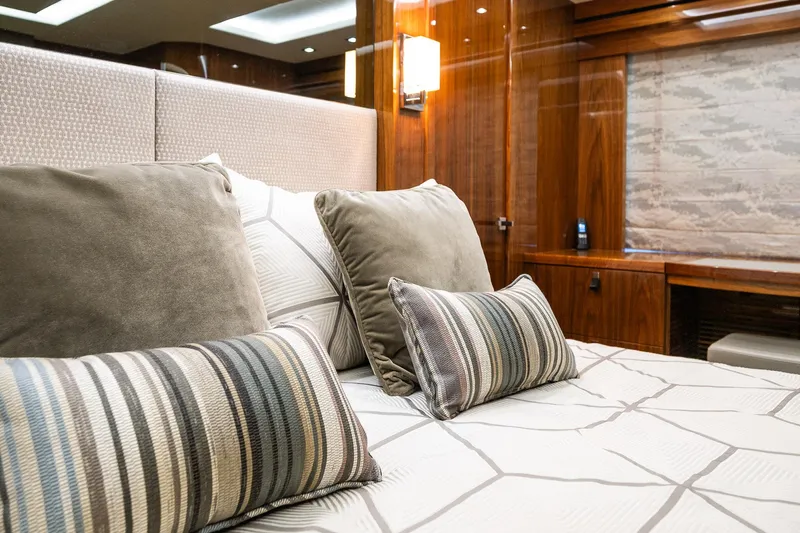 Seawater Yacht Photos Pics Luxurious bedroom interior on 2019 Sunseeker 86 Yacht with plush pillows and elegant wood paneling.