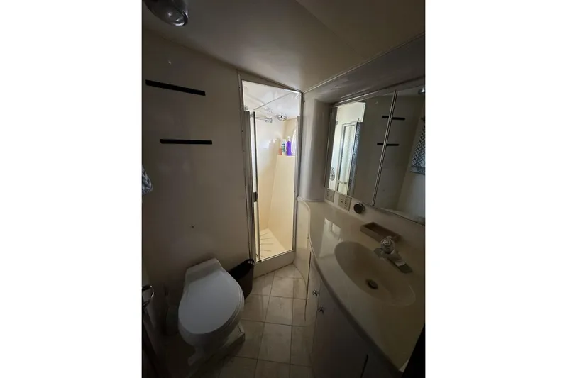 Summer Shack Yacht Photos Pics Bathroom interior of 1988 Hatteras 48 Convertible yacht, featuring shower, toilet, and sink.