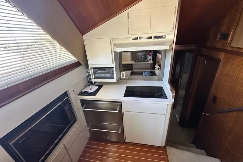 Summer Shack Yacht Photos Pics 1988 Hatteras 48 Convertible yacht kitchen with modern appliances and wood accents.