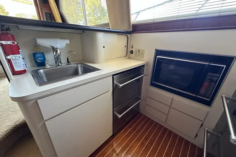 Summer Shack Yacht Photos Pics 1988 Hatteras 48 Convertible yacht kitchen with sink, microwave, and wooden flooring.