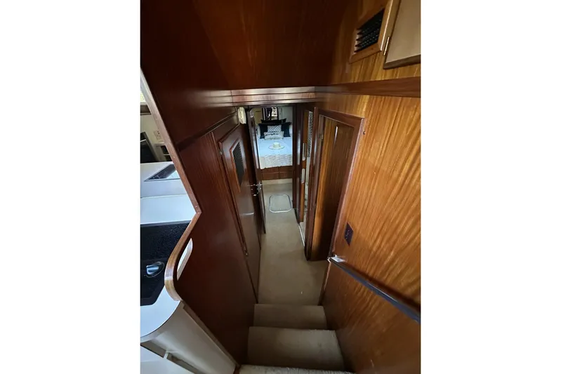 Summer Shack Yacht Photos Pics Interior view of 1988 Hatteras 48 Convertible yacht, featuring wooden walls and a cozy hallway.