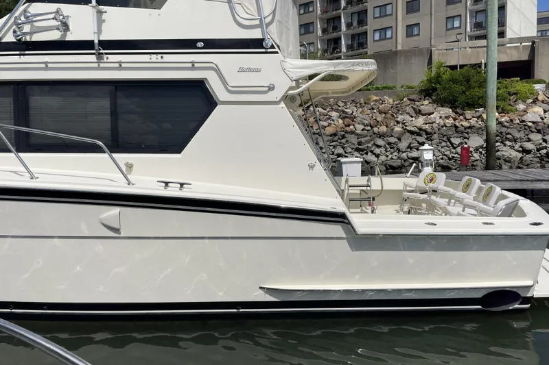 Summer Shack Yacht Photos Pics 1988 Hatteras 48 Convertible yacht docked near waterfront buildings.