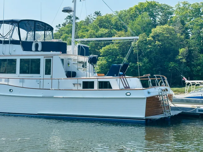 Sora Yacht Photos Pics 1998 Grand Banks 49 Classic yacht docked by lush green trees.