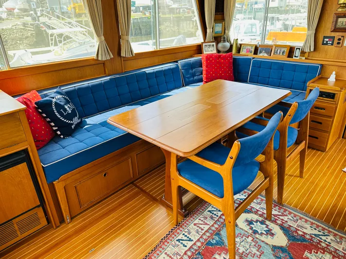 Sora Yacht Photos Pics Interior of 1998 Grand Banks 49 Classic yacht with blue seating and wooden dining table.