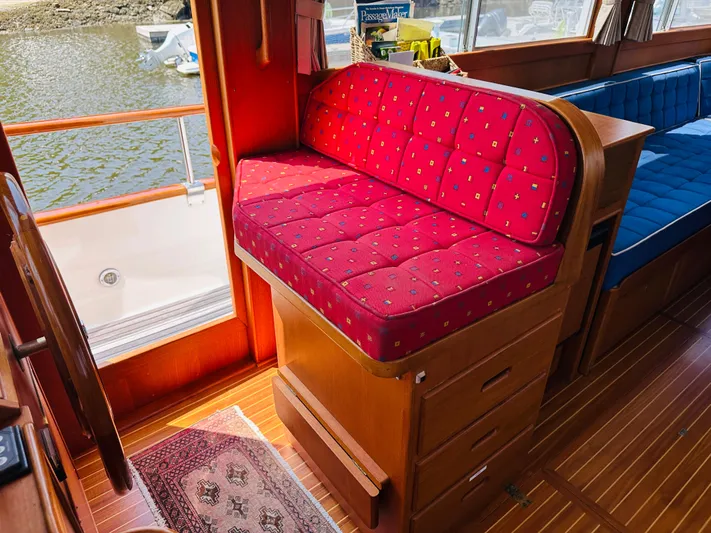 Sora Yacht Photos Pics Interior of 1998 Grand Banks 49 Classic with red cushioned seating and wooden flooring.