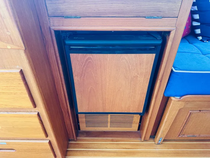 Sora Yacht Photos Pics Wood-paneled mini fridge in 1998 Grand Banks 49 Classic yacht interior.