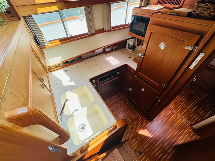 Sora Yacht Photos Pics 1998 Grand Banks 49 Classic yacht kitchen with wooden cabinetry and dual sink.