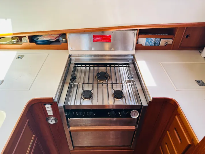 Sora Yacht Photos Pics 1998 Grand Banks 49 Classic yacht kitchen with stainless steel stove and wooden cabinetry.