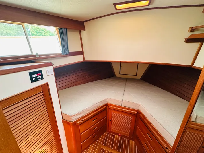 Sora Yacht Photos Pics 1998 Grand Banks 49 Classic cabin interior with wood finish and cozy bedding.