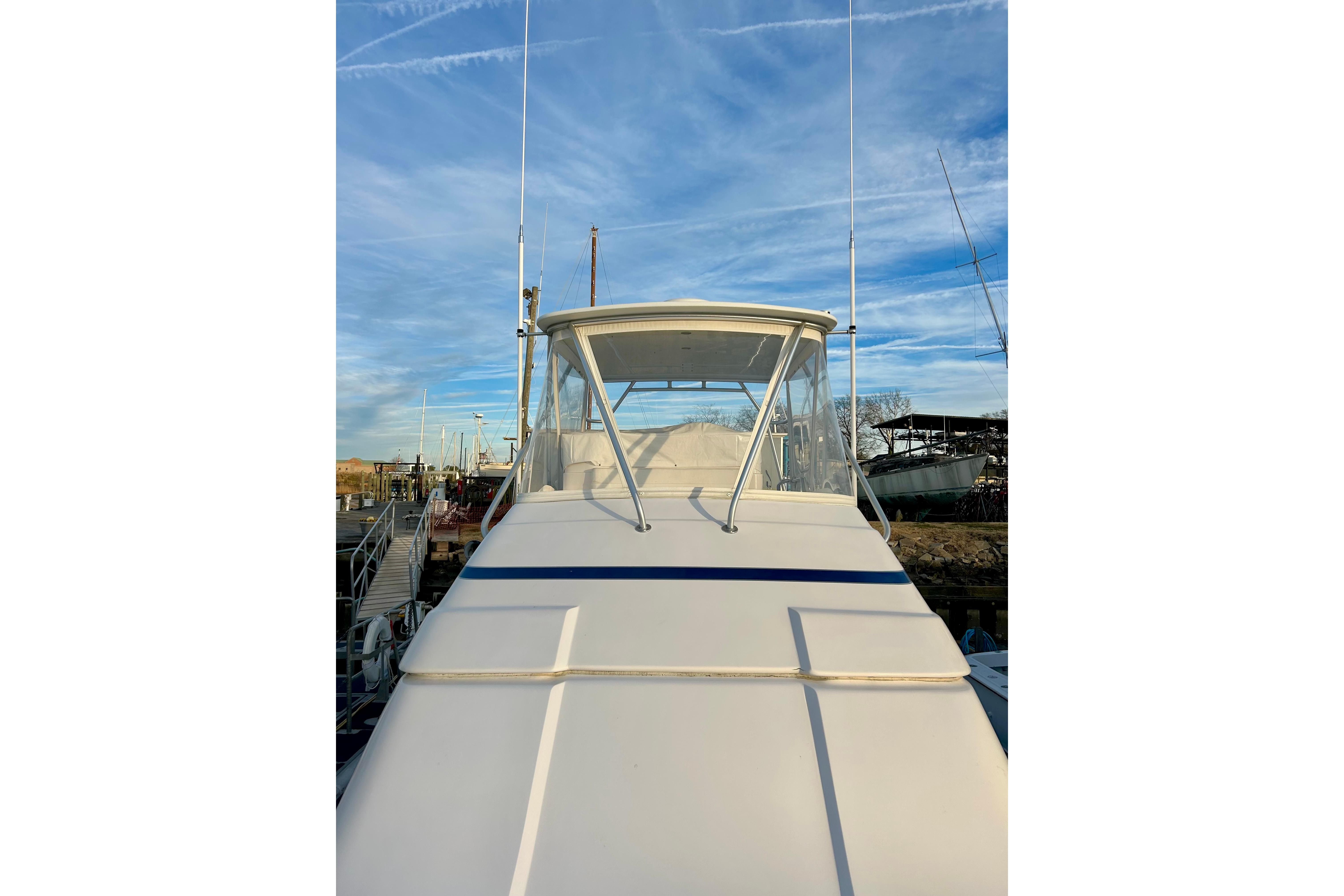 2005 Bertram 390 Convertible yacht docked under a clear blue sky.