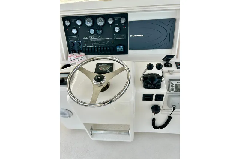  Yacht Photos Pics 2005 Bertram 390 Convertible helm with steering wheel and navigation controls.