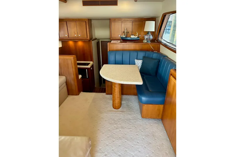  Yacht Photos Pics Interior of 2005 Bertram 390 Convertible yacht with blue seating and wooden cabinetry.