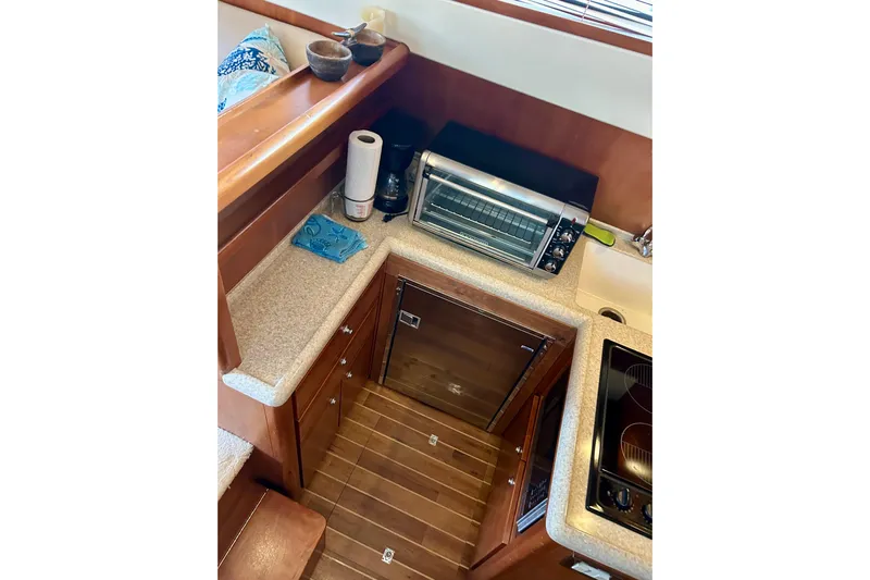  Yacht Photos Pics 2005 Bertram 390 Convertible yacht kitchen with appliances and wooden cabinetry.