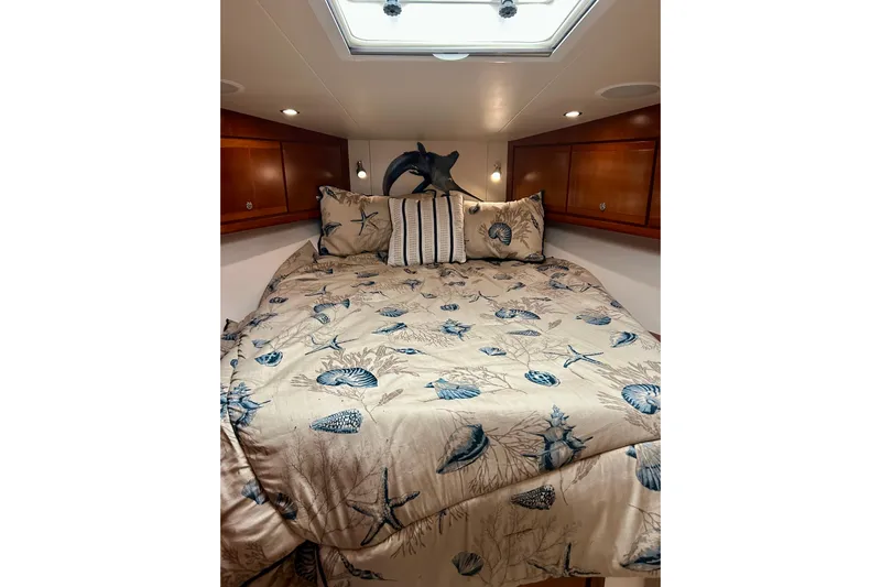  Yacht Photos Pics Luxurious cabin interior of 2005 Bertram 390 Convertible with nautical-themed bedding.