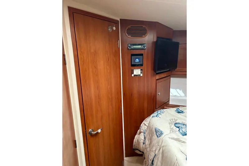  Yacht Photos Pics Interior of 2005 Bertram 390 Convertible with wood paneling, TV, and control panel.