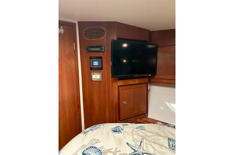  Yacht Photos Pics Interior of 2005 Bertram 390 Convertible with TV and wooden cabinetry.